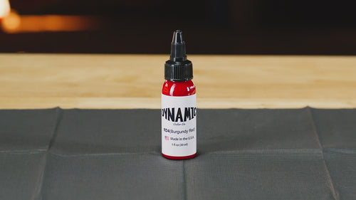 Dynamic Burgundy Red tattoo ink bottle on a countertop