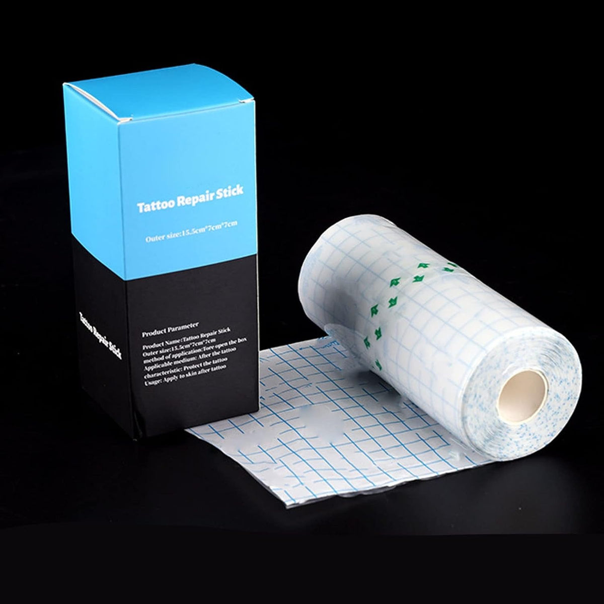 Tattoo protective film roll beside a blue and black box on a dark background