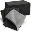 Stack of black disposable dental bibs with one bib folded forward